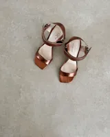 Sandalias plateadas con tira delantera, tobillera con hebilla y taco geométrico.