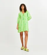 Vestido corto color verde lima con estampado de flores en verde claro, escote en V con lazo, mangas 3/4 con puños elásticos y falda con volantes.