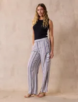 Pantalón de lino a rayas verticales en tonos beige, azul y blanco. Tiene pretina elastizada, bolsillos inclinados delanteros y bolsillo lateral tipo cargo.