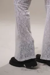 Pantalón de encaje blanco con short interno y corte en la rodilla.