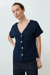 Remera verde oliva con escote en V, manga corta con dobladillo y cierre frontal con botones.