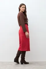 Falda midi de simil gamuza color rojo intenso, con tajo frontal central y paneles cosidos que le dan estructura.