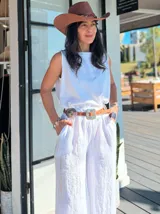 Blusa blanca sin mangas de lino, con cuello redondo y corte holgado.