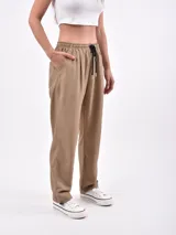 Pantalón de vestir color negro, de corte recto, con bolsillos laterales y traseros. Se ajusta a la cintura con cinturón de cuero marrón.