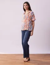 Blusa de gasa bambula estampada con cuello con solapa, escote en V y botón. Tiene un bolsillo aplicado en la parte delantera.