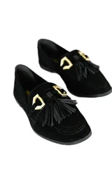 Mocasines negros de gamuza con detalle de borlas y aplique metálico dorado.