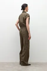 Mono de color verde oliva con cuello camisero, cierre frontal de botones y bolsillos tipo cargo. Presenta mangas cortas y cintura marcada.