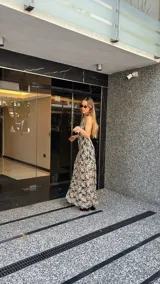 Vestido midi de encaje floral color beige sobre base negra, con cuello halter y falda con vuelo.