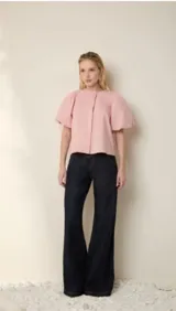 Jean de mezclilla azul oscuro, tiro alto, corte ancho y pierna acampanada. Presenta un diseño de talle alto con costuras frontales que simulan un cruce o doblez.