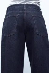 Pantalón de jean celeste de tiro bajo, corte flare, cropped y cinco bolsillos.