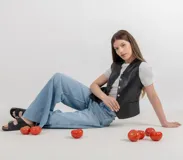 Chaleco color arena de cuero ovino, con cuello en V y cierre frontal con botones.