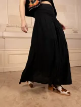 Falda larga negra acampanada con faja en la cintura.