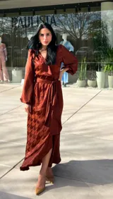 Vestido midi color marrón ocre con estampado de pata de gallo, corte cruzado, mangas largas abullonadas y lazo en la cintura.