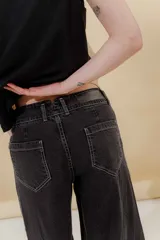 Pantalón de jean azul con corte sastrero de tiro medio bajo confeccionado en 100% algodón. Presenta cortes en los costados, dos bolsillos delanteros y dos traseros.