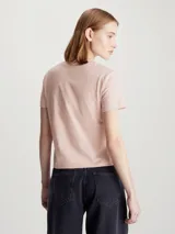 Remera rosa de algodón con cuello redondo y mangas cortas. Presenta múltiples logos de Calvin Klein Jeans en relieve.