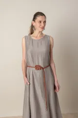 Vestido midi marrón de tejido tramado, corte suelto, sin mangas y con bolsillos laterales.