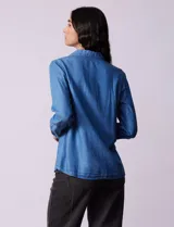 Camisa celeste de lyocell, marca Zac & Rachel. Cuello con solapa, abertura central con botones y bolsillos delanteros.