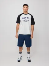 Remera azul marino con mangas raglán color crema y estampado frontal con el logo de Rusty en blanco.