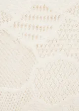 Vestido largo de tejido de punto fino color crudo, con cuello redondo, diseño entallado y mangas largas. Incluye cinturón de cadena dorada.