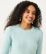 Buzo de punto color rosa claro, con cuello redondo y textura peludita.