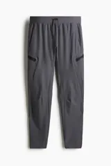 Pantalón de jogging deportivo gris oscuro, de corte ajustado, con cintura elástica ajustable con cordón, bolsillos laterales y bolsillos con cierre en las piernas.