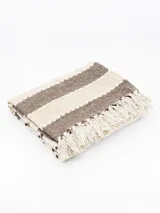 Pie de cama rectangular de algodón con diseño a rayas horizontales en tonos beige y marrón, con flecos en los extremos.