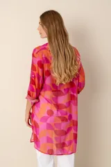 Camisa larga con estampado geométrico en tonos fucsia, naranja y rojo.