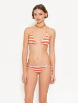 Conjunto de bikini a rayas horizontales naranjas y blancas, compuesto por un corpiño triangular con tirantes finos y una bombacha con tiras laterales ajustables.
