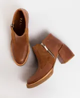 Botas cortas de cuero color marrón con cierre lateral, taco de madera forrado en cuero, entre suela de goma y horma de punta fina.
