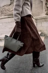 Bolso mini shopper de cuero sintético color gris oscuro, con doble asa de mano y detalles de ojales metálicos en los laterales. Incluye asa extraíble para llevar como bandolera y cierre magnético.