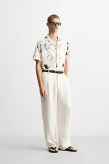 Camisa de manga corta con cuello bowling y estampado floral en tonos blanco y negro.