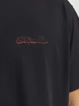 Camiseta negra de manga corta y cuello redondo con logo bordado en rojo en el pecho y estampado en la espalda.