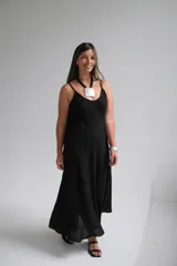 Vestido largo negro de breteles finos, corte recto y falda amplia.