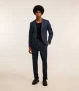 Pantalón de vestir azul marino, de corte recto, con bolsillos laterales y traseros. Se ajusta a la cintura con cinturón de cuero marrón.