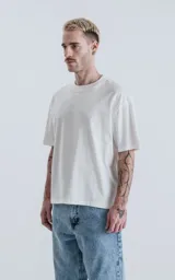 Remera blanca de algodón con corte crop, calce oversize, hombros caídos y cuello redondo.