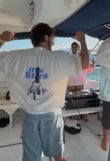 Camiseta celeste con estampado frontal de la frase "Ittai Stars" y una estrella. En la parte posterior tiene un estampado de un llavero con llaves y dijes.