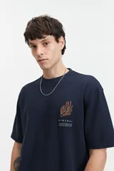 Remera color beige de manga corta con textura y corte oversize. Presenta un pequeño bordado en relieve en el frente.