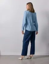 Camisa celeste de lyocell, marca Zac & Rachel. Cuello con solapa y abertura central con botones. Delantera con bolsillos.