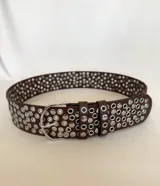 Cinto marrón de cuero sintético con tachas plateadas.