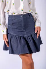 Falda corta de jean azul con volados en el ruedo y costuras en hilo blanco.