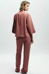 Pantalón de vestir color beige, de tiro alto, con cintura elástica en la parte trasera, bolsillos delanteros y falsos bolsillos de vivo en la parte trasera.