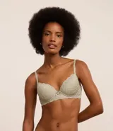 Soutien femenino modelo base con relleno hueco, confeccionado en encaje rústico. Posee tirantes finos ajustables y un pequeño lazo con medalla aplicada en el centro.