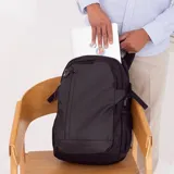 Mochila negra con bolsillo frontal vertical y capacidad para notebook. Incluye bolsillos laterales de rejilla, además de una faja y un bolsillo en la espalda para sujetarla a la valija.