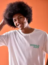 Remera blanca de algodón con cuello redondo y estampado frontal con el texto "Donald Duck" en color verde.