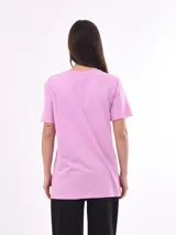 Remera de algodón color lila con cuello redondo y manga corta. Estampado frontal en naranja con el texto "RAISED ON 90'S COUNTRY" y estrellas.