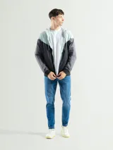 Campera deportiva con capucha, color celeste en la parte superior, negro en la parte inferior y mangas grises.