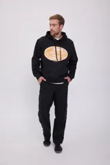 Hoodie negro con capucha y manga larga, de corte holgado y estampado ovalado en el pecho.