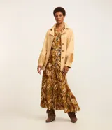 Vestido midi de viscosa con estampado de follaje en tonos marrones y verdes. Tiene cuello en V, cierre frontal con botones, mangas largas con elástico en los puños y corte evasé.