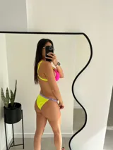 Conjunto de bikini fucsia con tiras amarillas y bombacha amarilla con borde lila.