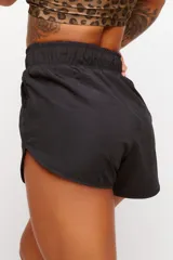 Short deportivo negro de tejido suave con elástico en la cintura y cordón ajustable.